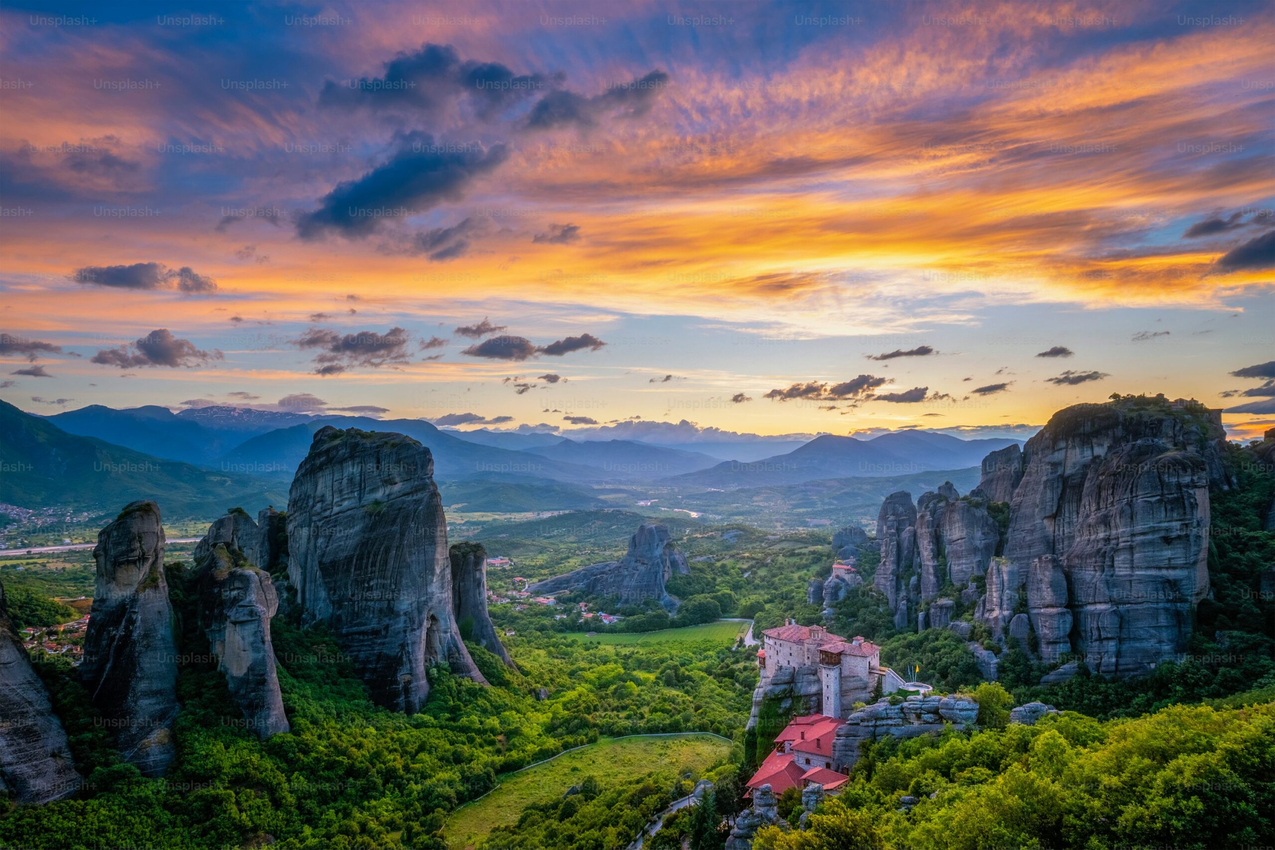 Panoramic sunset view of Meteora monasteries built on rocky cliffs in Thessaly, Greece