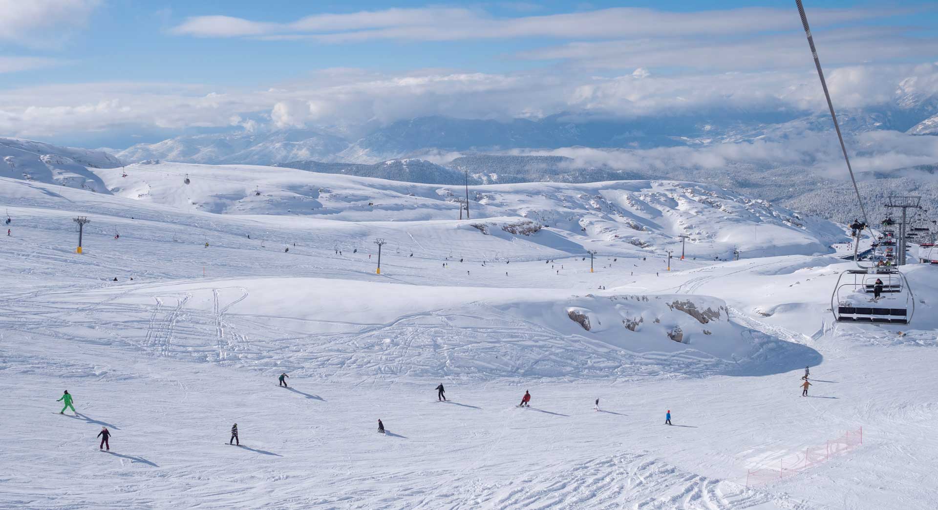 Skiers at Mount Parnassos ski resort in Greece with snowy slopes and ski lifts