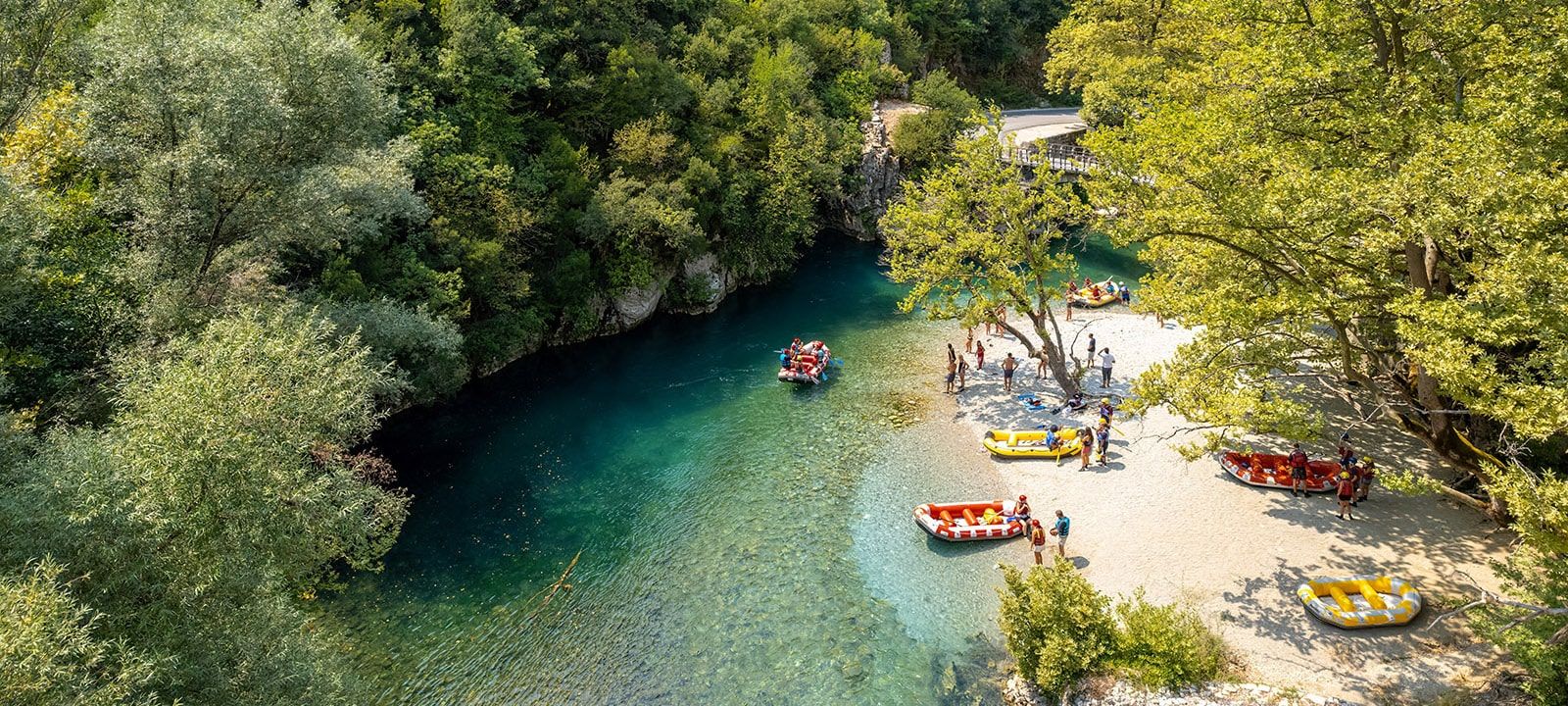 Travelers rafting on the turquoise waters of Voidomatis River in Zagorochoria, Epirus, Greece